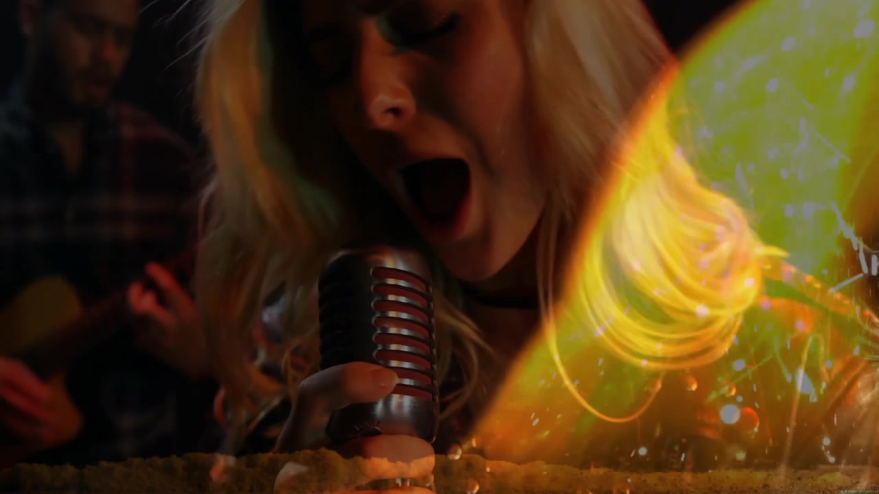 Cantante che afferra il microfono e inizia la performance su un palco musicale, chitarrista che strimpella, con un effetto di fiamme danzanti in sovrapposizione