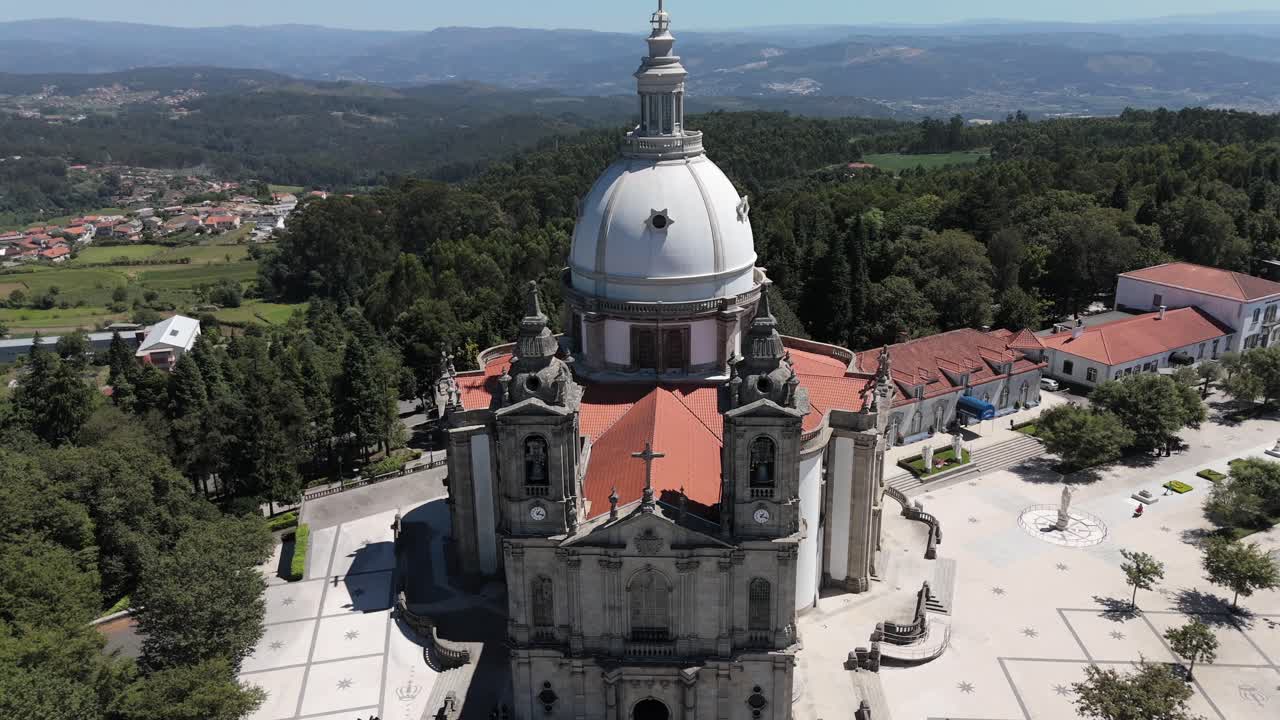 Drone view of the Sanctuary of Sameiro's dome with surrounding forest and distant mountains