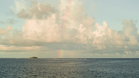 a cloudy afternoon view of a rainbow from catangnan bridge in siargao, philippines.