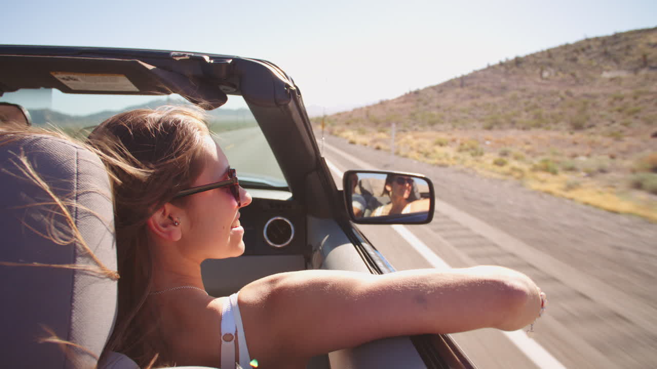 Couple On Road Trip Driving In Convertible Car Shot On R3D