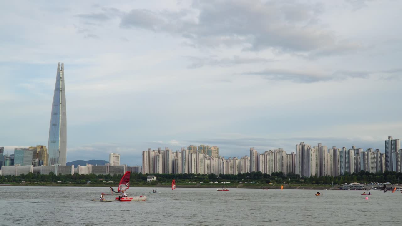해질 무렵 한강에서 수상 스포츠를 하는 사람들, 한국 서울 스카이라인을 배경으로 한 롯데월드타워 랜드마크 빌딩