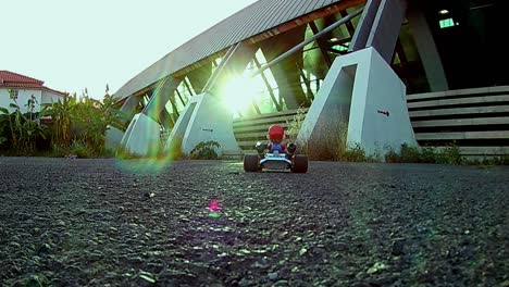 close-up de um kart de corrida com tema super mario controlado por rádio rc decolando em uma estrada de asfalto real em um dia de sol brilhando