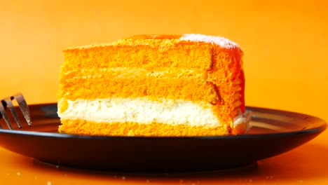 slice of orange cake on a black plate