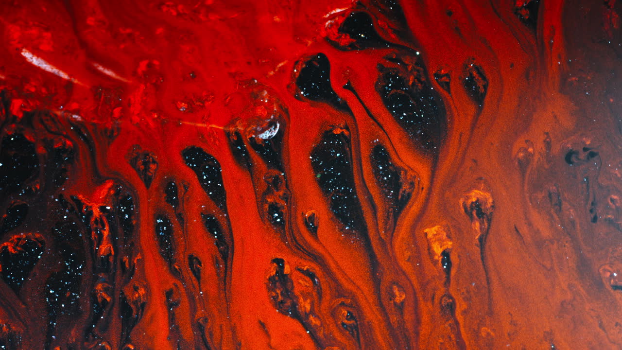 Vivid close-up of red substances swirling together in dynamic motion