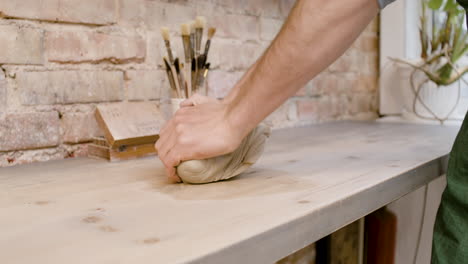 close up view of the hands of an clerk kneading clay on top of a table in a pottery workshop 1