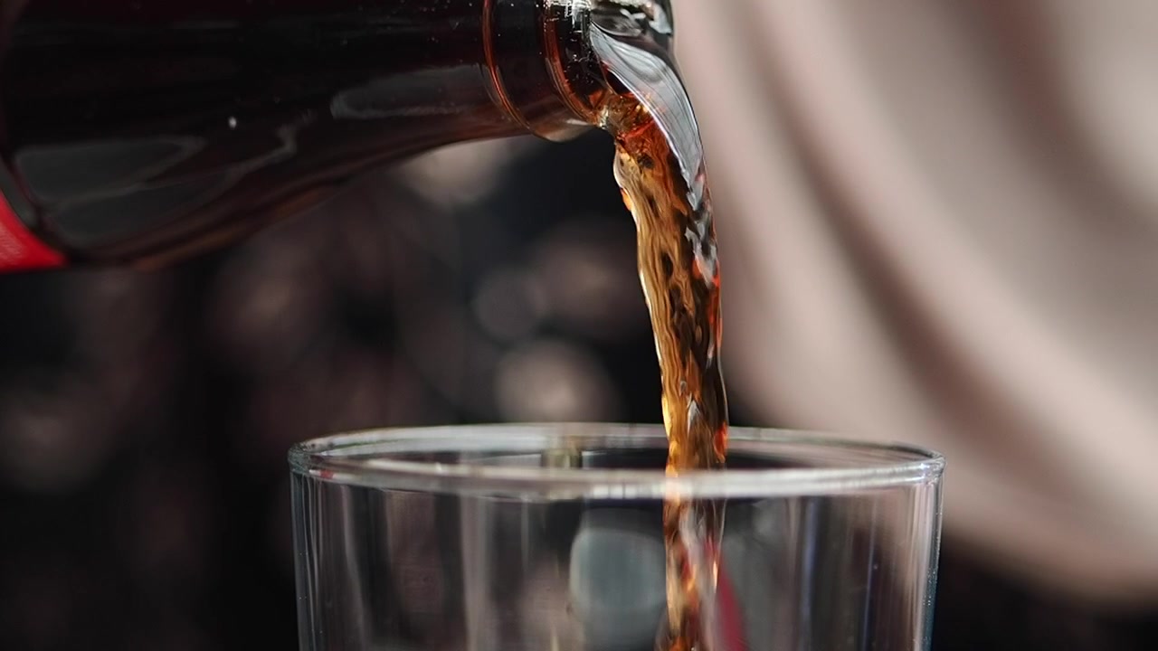 Primo piano di una bibita cola versata in un bicchiere