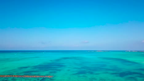 las aguas color esmeralda de una playa tropical se ensanchan en un horizonte de agua pura