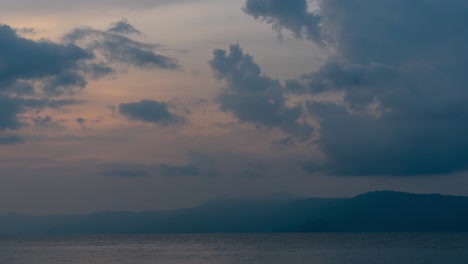 evolving sky and clouds over a mountainous lake at dusk