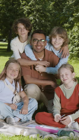 Group of children and an adult enjoying an outdoor learning activity in a park