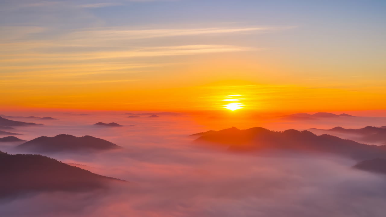 Zeitraffer des Sonnenaufgangs über Bergen und Nebel