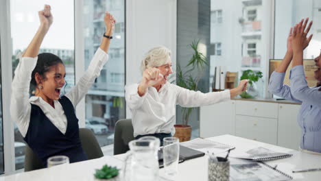 successful businesswomen celebrating achievement in office meeting