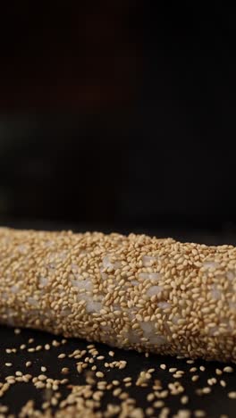 preparing a sesame-covered sushi roll