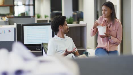 video of happy diverse businesswoman and businessman eating and talking in office