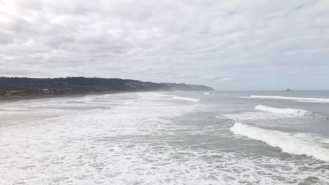 Dolly-Aufnahme-In-Zeitlupe-Von-Wellen,-Die-Auf-Den-Strand-Von-Muriwai,-Neuseeland,-Krachen