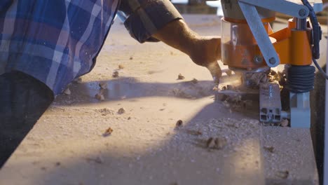 the carpenter is cleaning the chips and dust from the wood.