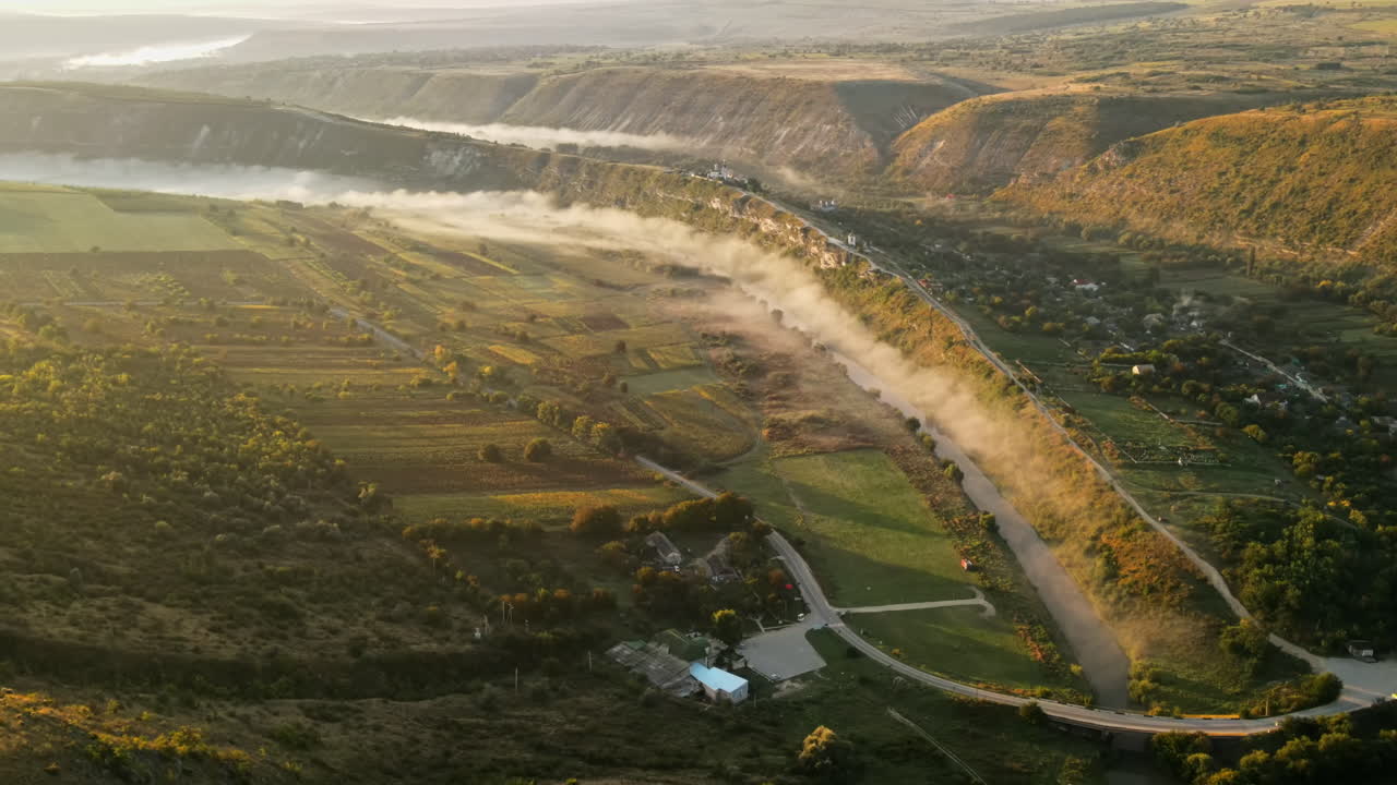 Aerial drone view of the Old Orhei at sunset. Valley with river and fog, village, monastery located on a hill in Moldova