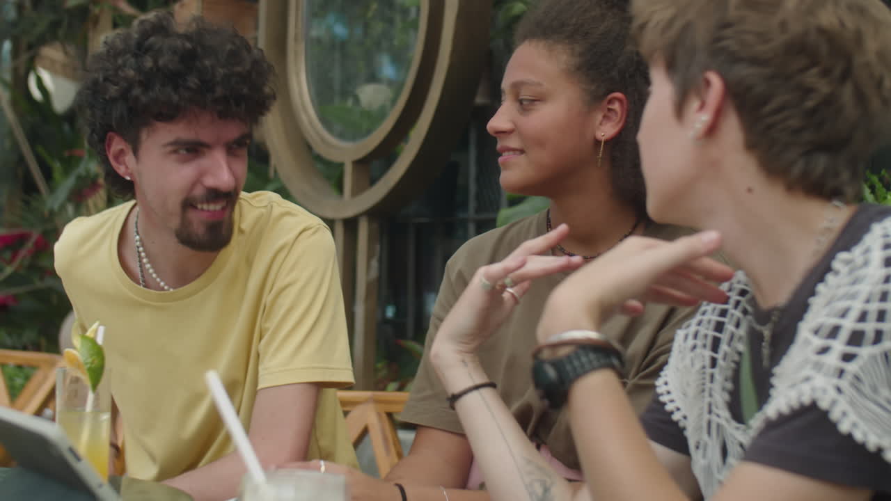 Friends Talking over Drinks in Outdoor Cafe