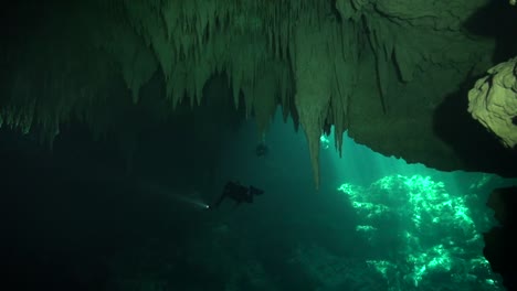 diver lights up the textured cavern ceiling