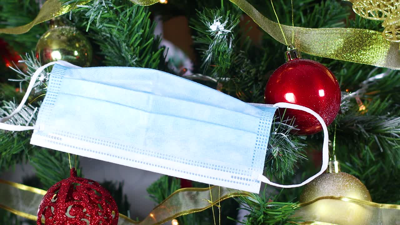 poniendo máscara facial en el árbol de navidad