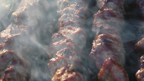 Closeup-smoked-bbq-roasting-on-brazier.-Pork-kebabs-grilling-on-skewers