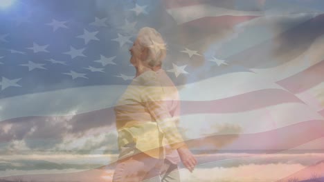 animation of happy senior caucasian couple walking on beach over flag of united states of america