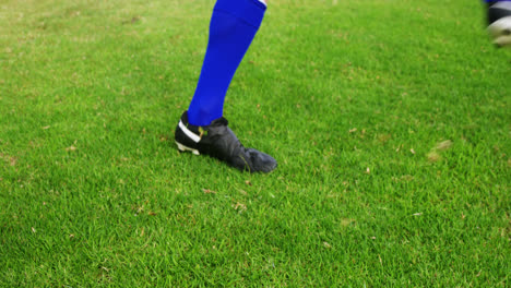 jugador de fútbol pateando una pelota en el campo