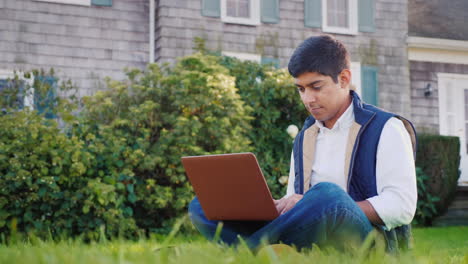 man works on laptop in yard