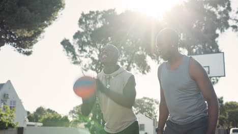 two men playing basketball outdoors