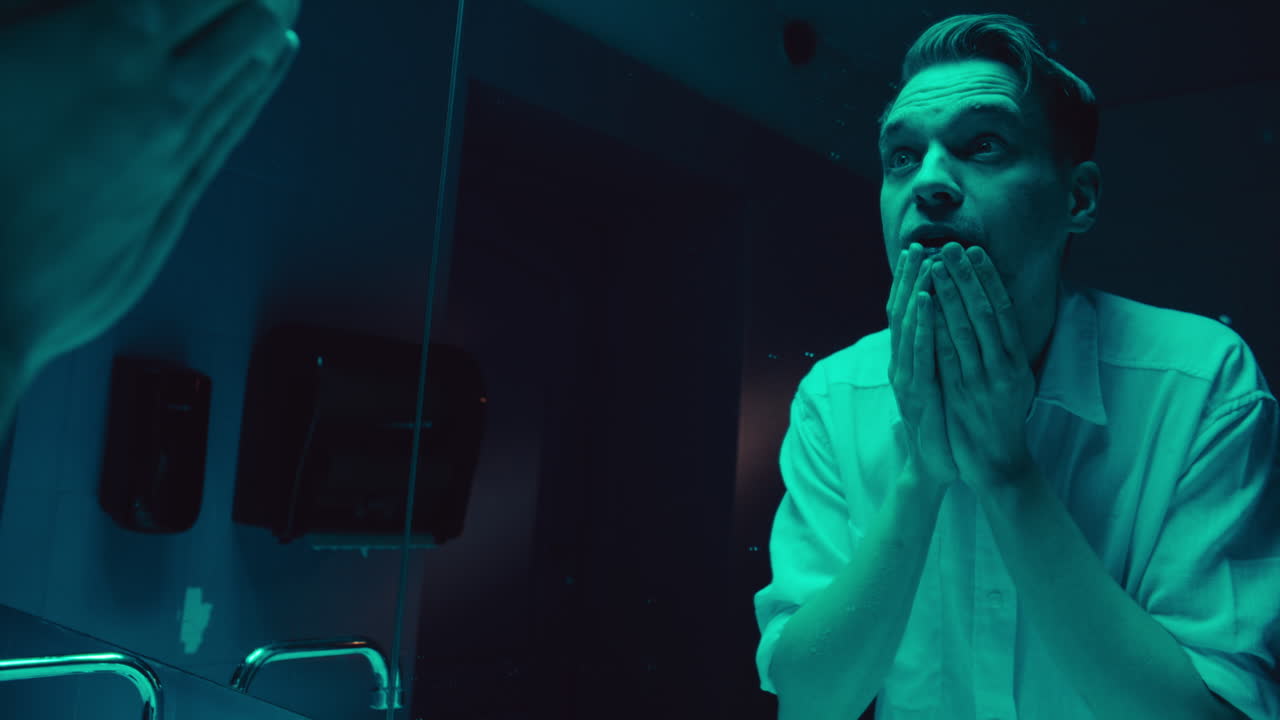 Man in bathroom looking in mirror