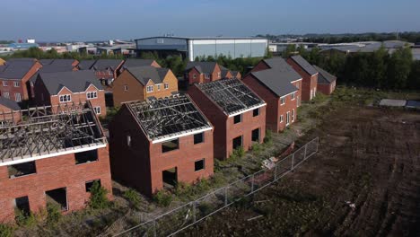 residential housing framework aerial view orbiting across unfinished rooftop development on urban building site real estate