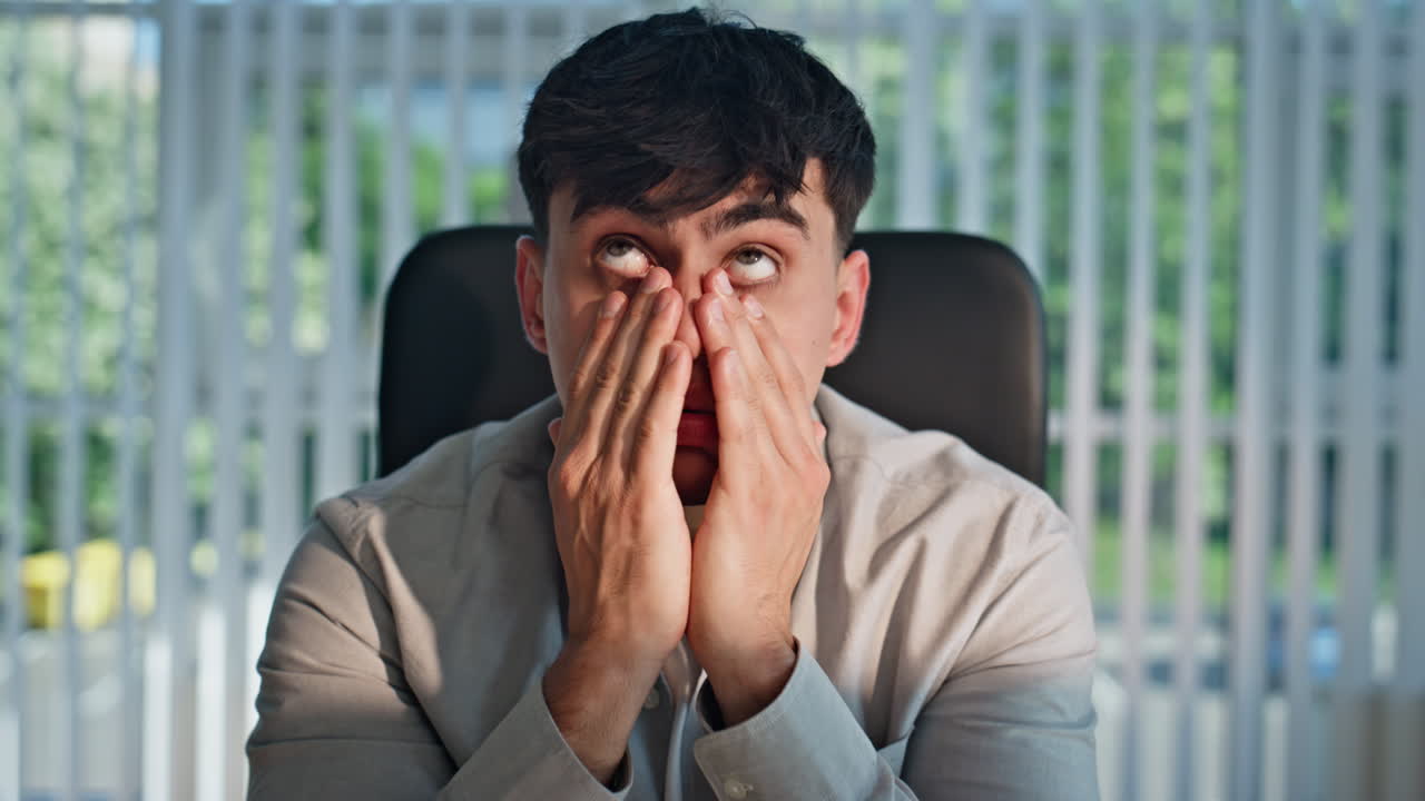 Serious manager looking computer workplace closeup. Exhausted man rubbing eyes