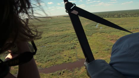 a young photographer photographing the landscape from a helicopter