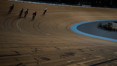 intense cycling action on a velodrome: riders compete in high-speed race while navigating the banked wooden track with precision and strategy