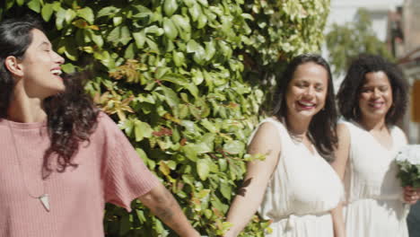 dolly shot of bridesmaids and lesbian newlyweds having funny photoshoot after wedding ceremony