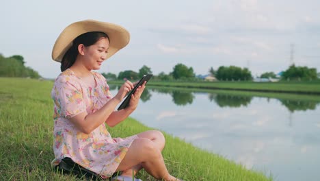 adult woman sitting on the lawn using portable technology