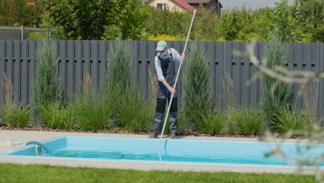 staff cleaning the pool with a vacuum cleaner to collect debris from the bottom