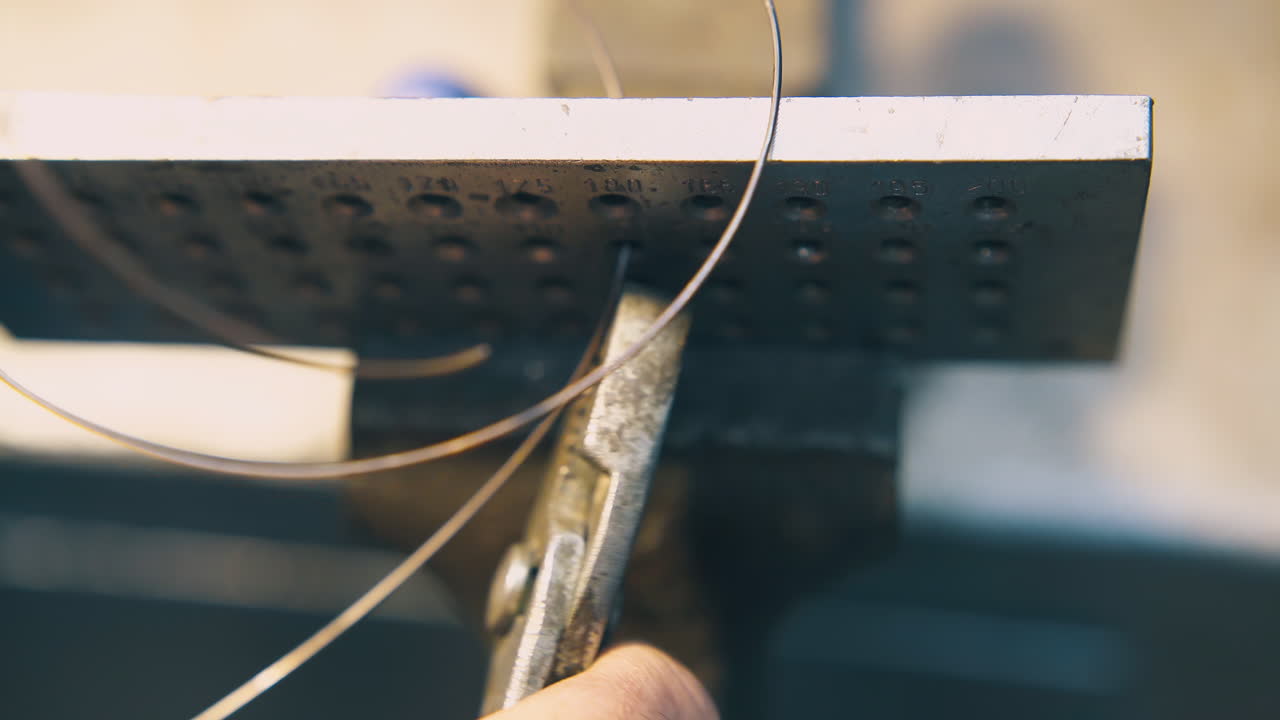 보석업자 는 도구 를 통해 금 케이블 을 끌고 가고 있다