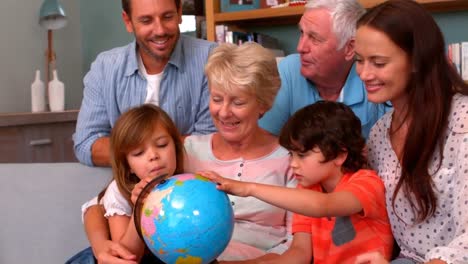 family on sofa looking at globe