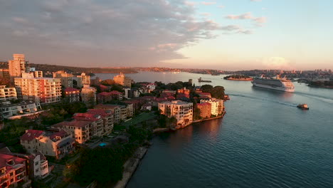 aerial over kirribilli residential and sydney harbour at sunset, cruise liner in distance, dolly forward