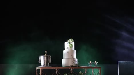 luxurious wedding cake and champagne setup on a decorated table at night