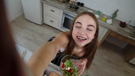 una foto de una blogger haciendo fotos, tomando selfies con ensalada para las redes sociales en el teléfono móvil