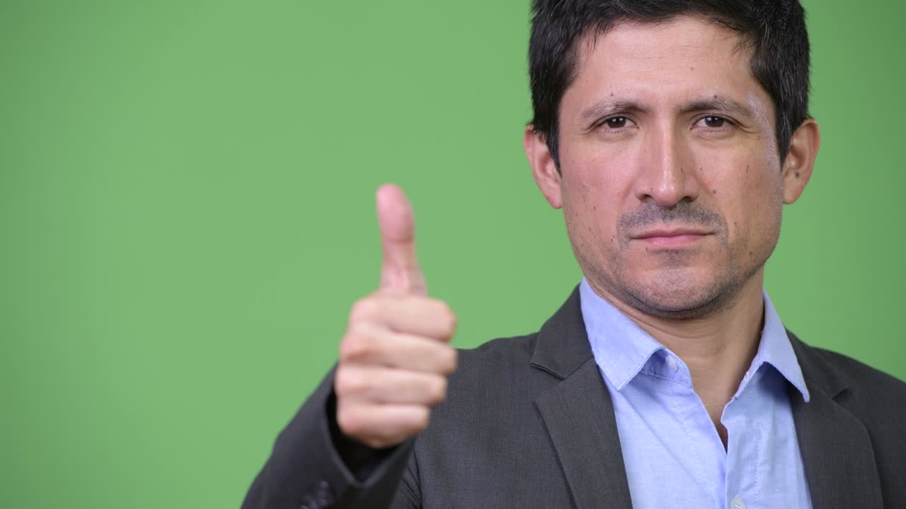 Happy Hispanic businessman giving thumbs up