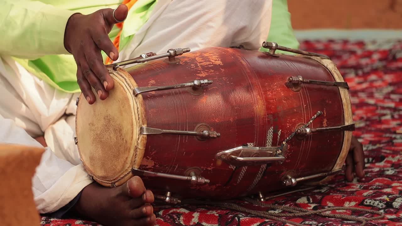 Rajasthan, Indian. Drummer playing traditional indian instrument in the street.
