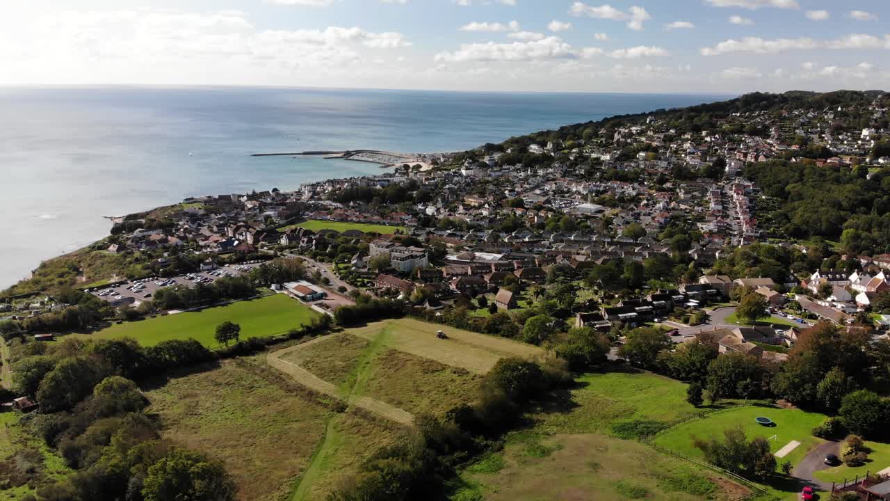 antena sobre campos con vista de la ciudad de lyme regis en segundo plano.