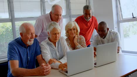 front view of active mixed-race senior people using laptop at nursing home 4k