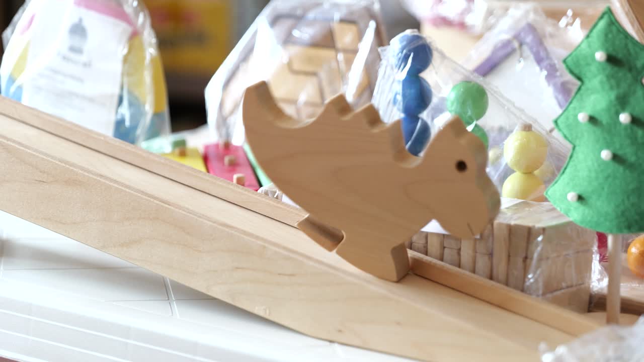 작은 나무 공이 천천히 램프를 내려가며, 손으로 만든 장난감