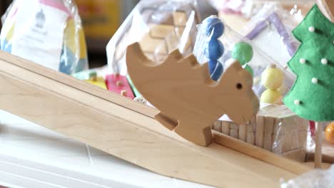 small wooden dinosaur slowly moves down ramp, handmade toy