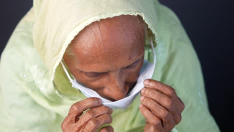 elderly woman wearing mask and hijab