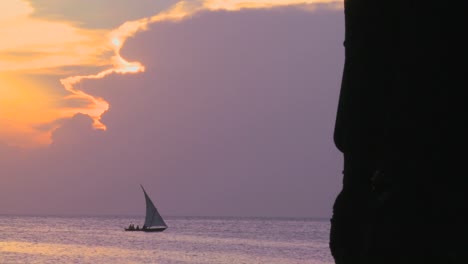 a sailboat silhouetted against a beautiful sunset in zanzibar