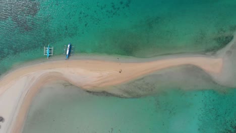 Aerial-top-view-of-an-Island-with-boats-and-people-playing-and-swimming-on-its-beautiful-clear-waters